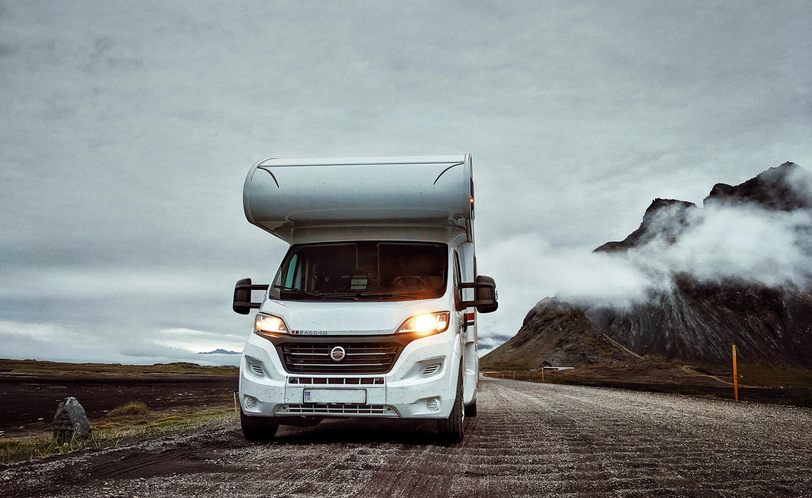 A motorhome on a road beneath mountains